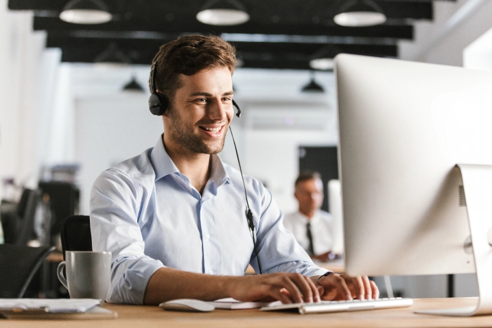 man working at computer with headset