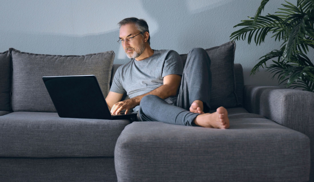 man on couch with computer